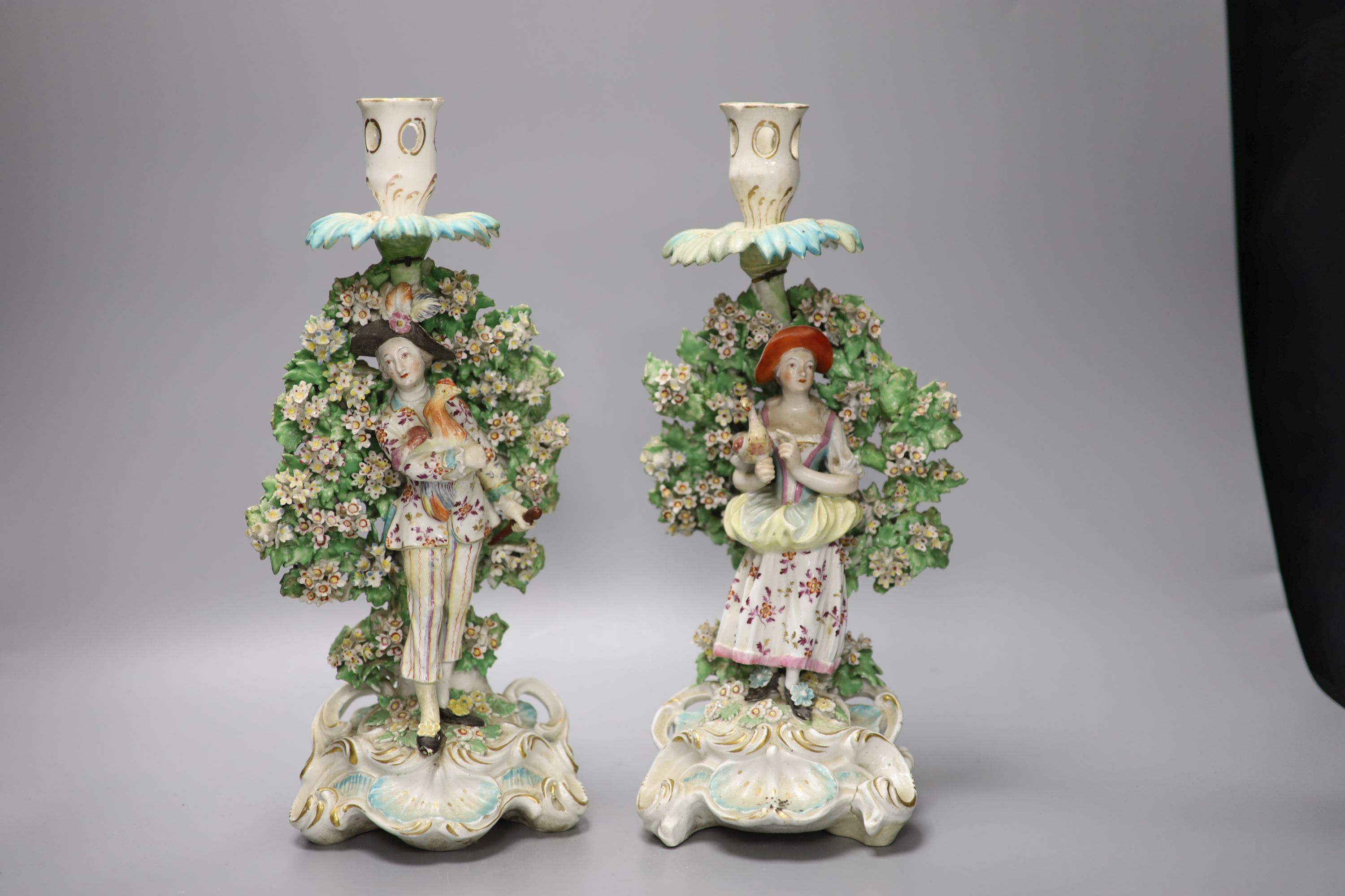 A pair of Derby bocage figural candlesticks, of the Italian farmer and his wife, c.1770, height 31.5cm